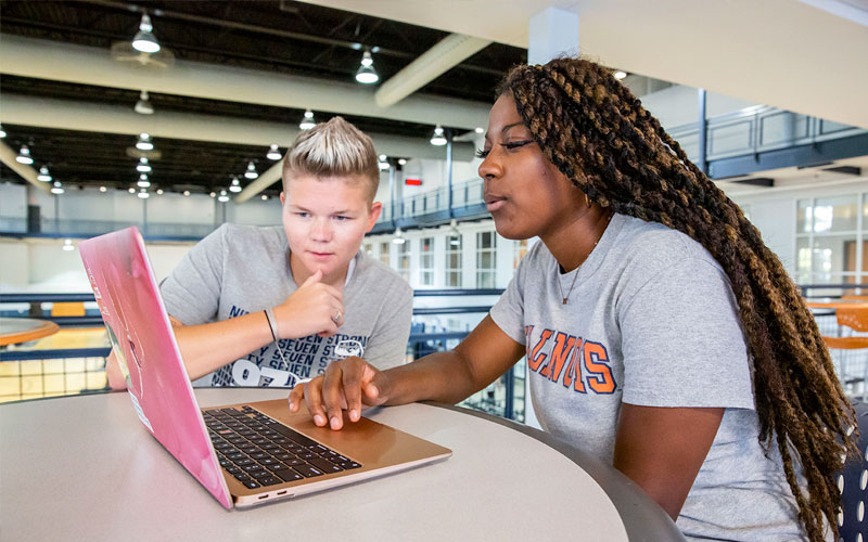 2 women studying a laptop screen