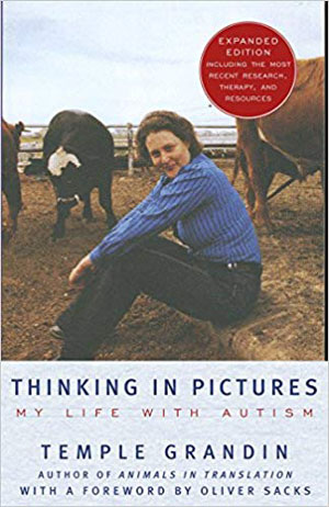 Temple Grandin sitting in a cattle pen