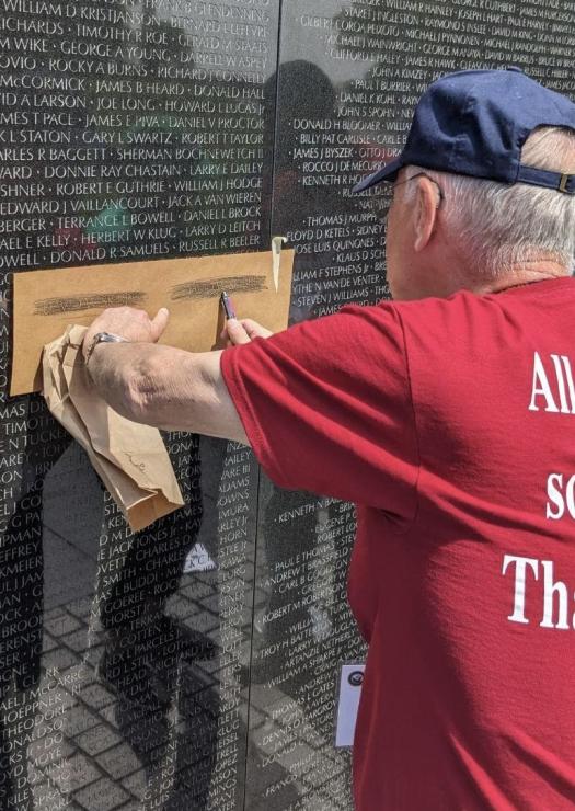 Joe Rank does a charcoal rubbing of his classmate Lt. David Skibbe's name on the Vietnam War Memorial Wall in Washington, D.C. 