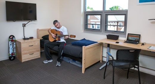 Image of a student playing guitar in Chez housing