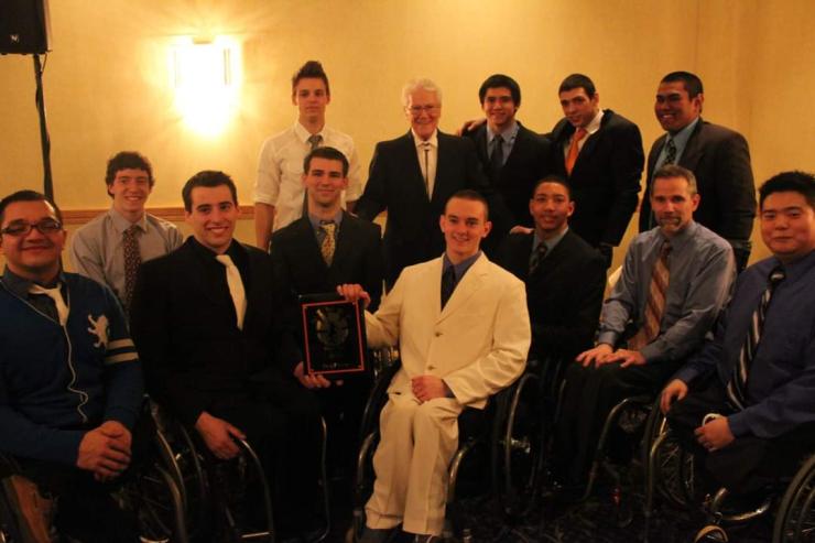 Men's wheelchair basketball players pose with Tim Nugent (second row, second from left) and Coach Mike Frogley (first row, second from right). 