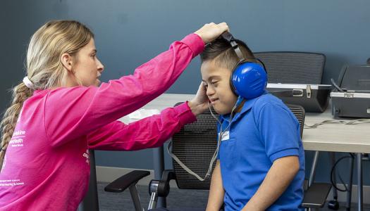 An SHS audiology student performs a hearing test on a child at MedFest, hosted at the Wintrust Sports Complex. 