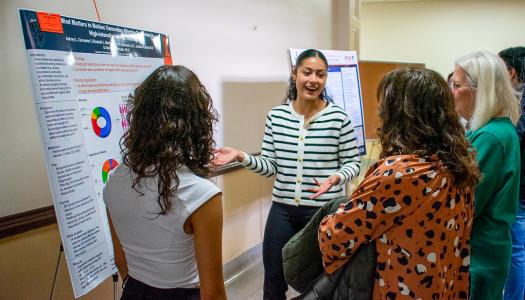 Kinesiology juniors Elizabeth Martinez (center) and Aubrey Cervantes (left) present their research at the AHS Undergrad Research Expo on April 24, 2024. 