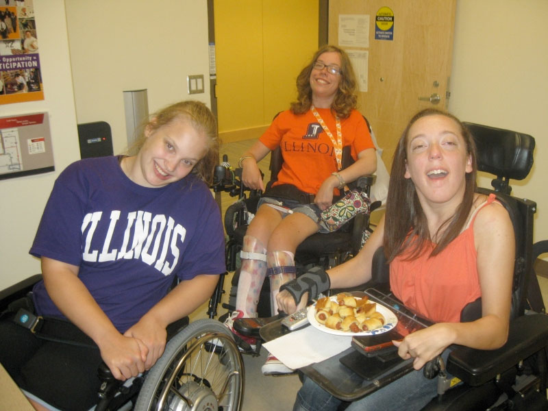 3 smiling students in wheelchairs